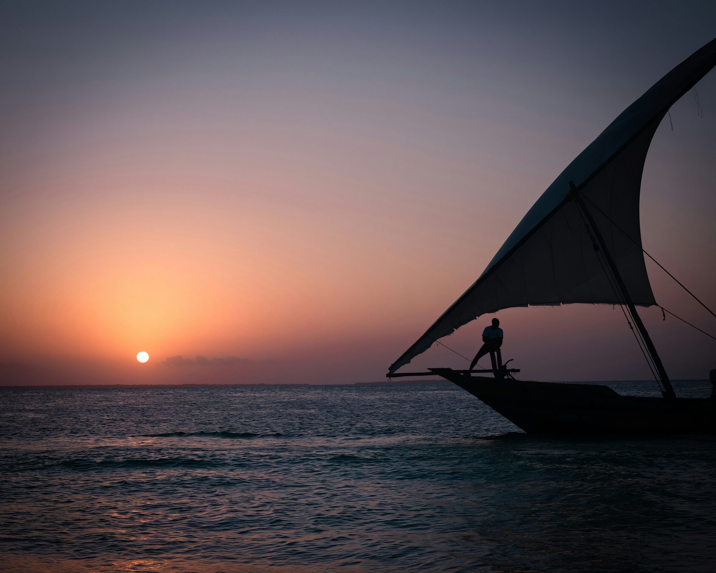 A dhow under sail at sunset off the Zanzibar coast